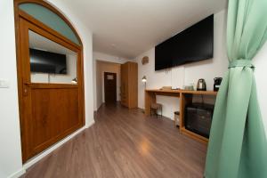 a living room with a large door and a television at Pescariei Nr5 in Sarichioi