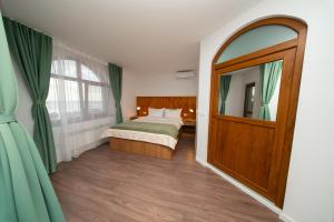 a bedroom with a bed and a mirror and a door at Pescariei Nr5 in Sarichioi +47 photos