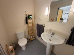 a bathroom with a white toilet and a sink at Casa Hjort in Nerja