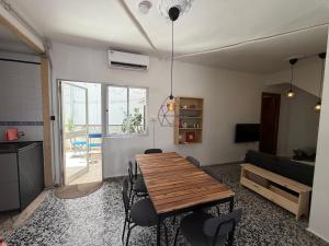 a living room with a wooden table and chairs at Casa Hjort in Nerja +14 photos