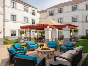 a patio with chairs and a fire pit in front of a building at Hyatt House Boston/Burlington in Burlington