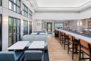 a dining room with tables and chairs and windows at Hyatt House Boston/Burlington in Burlington