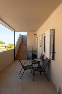 a balcony with a table and chairs and stairs at Perdika center rooms in Pérdika