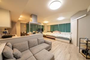 a living room with a couch and a bed at 高田馬場 Yoko hotel shinnjuku, shinokubo 10 people stay, big room in Tokyo