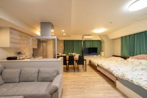 a room with two beds and a couch and a kitchen at 高田馬場 Yoko hotel shinnjuku, shinokubo 10 people stay, big room in Tokyo