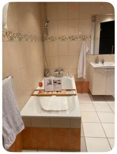 a bathroom with a sink and a bath tub at Skøn perle midt i naturen in Munke Bjergby