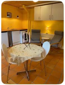 a table and chairs in a kitchen with yellow walls at Skøn perle midt i naturen in Munke Bjergby