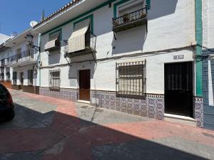 a white building with windows and balconies on a street at Casa Hjort in Nerja