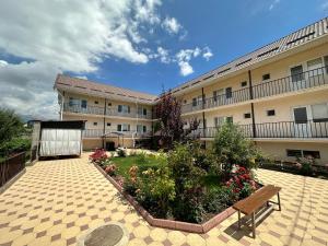 a building with a bench and flowers in a courtyard at Jany Tilek in Bosteri