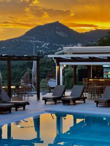 a resort with a pool and a mountain in the background at Maria Resort Parga in Parga