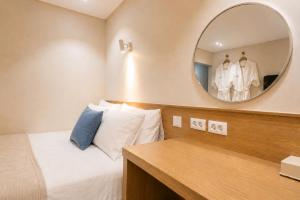a bedroom with a bed and a mirror at 부산 수영 블루닷 호텔 in Busan