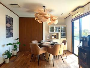 a dining room with a table and chairs and a chandelier at Villa Nami in Kashima