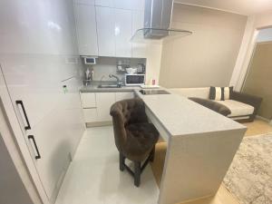 a kitchen with a counter and a chair in a room at Wh in HighVill in Astana +4 photos