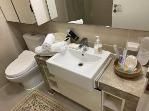 a bathroom with a sink and a toilet and a mirror at Wh in HighVill in Astana
