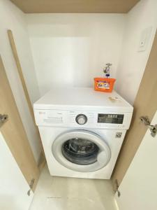a washing machine in a laundry room with an orange box on top at Wh in HighVill in Astana