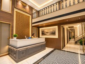 a woman sitting at the reception desk of a hotel lobby at Hotel Next View Amritsar # Pool # Parking # Family Hotel # Best choice for Tourists in Amritsar +23 photos