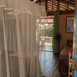 a room with a white curtain and a window at Kitesurfing Lanka in Kalpitiya