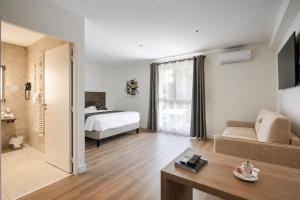 a living room with a bed and a couch at Logis Hotel Le Petit Casset in La Boisse