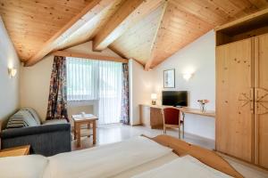 een woonkamer met een bed en een bureau bij Hotel Kirchdach in Gschnitz