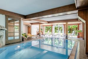 een binnenzwembad in een huis met stoelen en tafels bij Hotel Kirchdach in Gschnitz