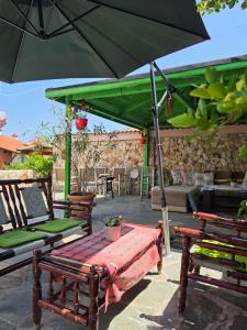 a group of chairs and an umbrella on a patio at Студия Синя приказка in Sozopol