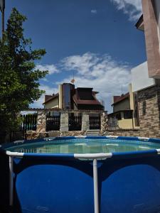 a large blue swimming pool in front of a house at Студия Синя приказка in Sozopol