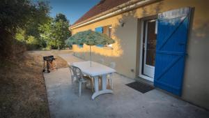 a table with an umbrella next to a building at Maison Grebert in Gouffern en Auge
