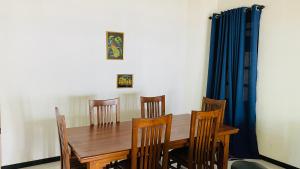 a dining room with a wooden table and chairs at MAYU Homestay in Dickwella