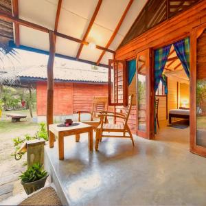 a porch of a house with a table and chairs at Kitesurfing Lanka in Kalpitiya