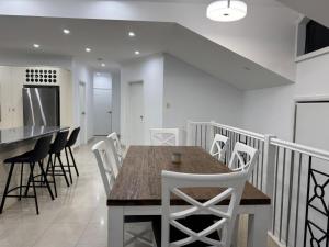 a kitchen and dining room with a wooden table and chairs at Sapphire By The Sea in Diamond Beach +9 photos