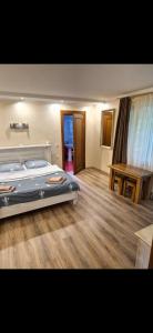 a bedroom with a bed and a wooden floor at Над Річкою in Yaremche