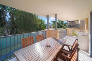 a wooden table and chairs on a deck at Sapphire By The Sea in Diamond Beach