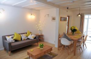 a living room with a couch and a table at Stowaway Beach House Camber Sands in Camber