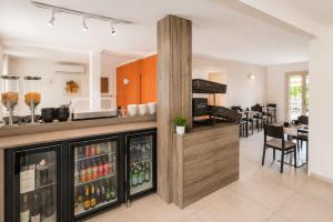 a kitchen with a bar with drinks in it at Logis Hotel Le Petit Casset in La Boisse