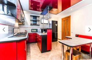 a kitchen with red cabinets and a table in it at Над Річкою in Yaremche