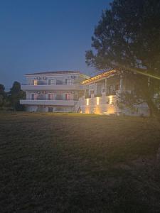 a large building with lights in a field at Magenta Beach in Porto Heli