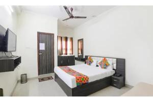 a bedroom with a bed and a flat screen tv at FabHotel Sara Residency in Prayagraj