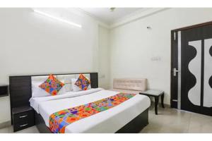 a bedroom with a large bed with a colorful blanket at FabHotel Sara Residency in Prayagraj