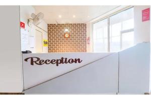 a sign for a reception in a building at FabHotel Sara Residency in Prayagraj
