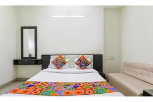 a bedroom with a bed with a colorful blanket on it at FabHotel Sara Residency in Prayagraj +24 photos