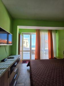 a bedroom with a bed and a sliding glass door at Студия Синя приказка in Sozopol