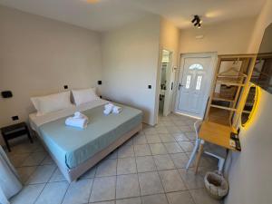 a bedroom with a bed with white towels on it at Magenta Beach in Porto Heli +12 photos
