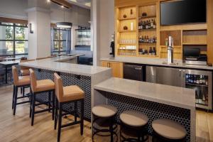 a large kitchen with a bar with stools at Hyatt Place Dublin/Pleasanton in Dublin