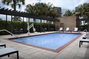 a pool at a hotel with chairs and tables at Home2 Suites by Hilton Florida City in Florida City