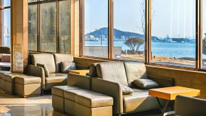 a waiting room with a couch and tables and windows at Incheon Grace Hotel in Incheon