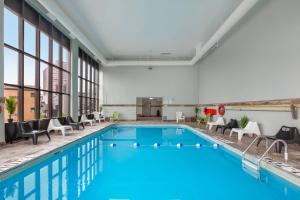 a pool in a hotel room with chairs and tables at Quality Inn & Suites in Niagara Falls