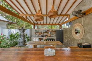 an outdoor dining area with a table and a kitchen at Noho Stay Bali in Uluwatu