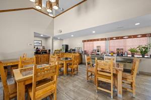 a restaurant with wooden tables and chairs and a counter at Econo Lodge Inn & Suites Santa Fe South in Santa Fe
