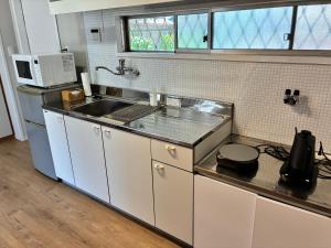 a kitchen with a sink and a microwave at Recasa in Imabari