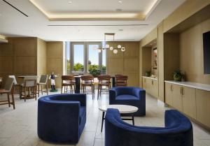 a lobby with blue chairs and a table at Hilton Arcadia Los Angeles in Arcadia
